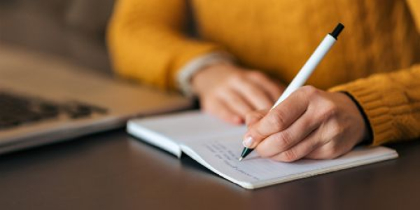 Image of Swinburne Student writing in notebook